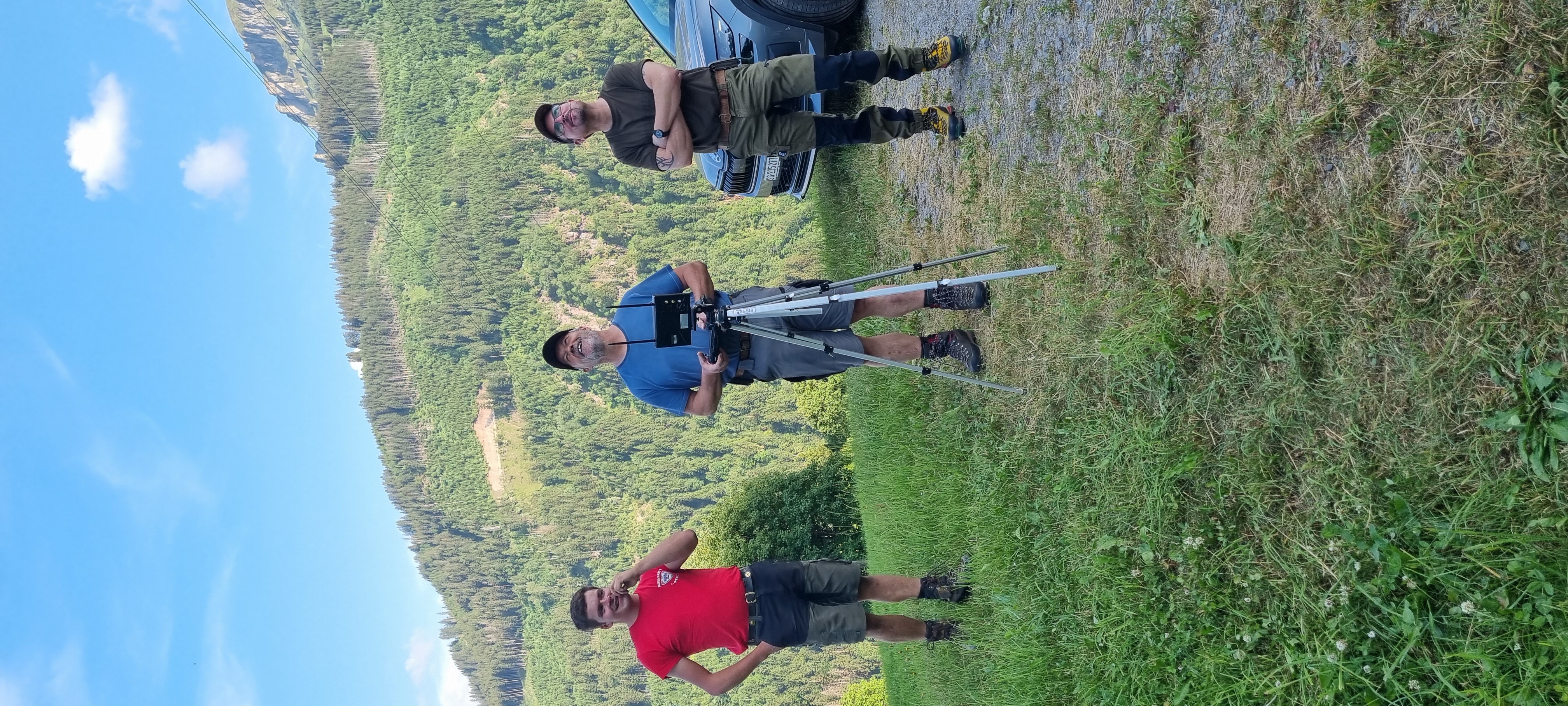 Team mit Drohnenausrüstung auf einer Bergwiese