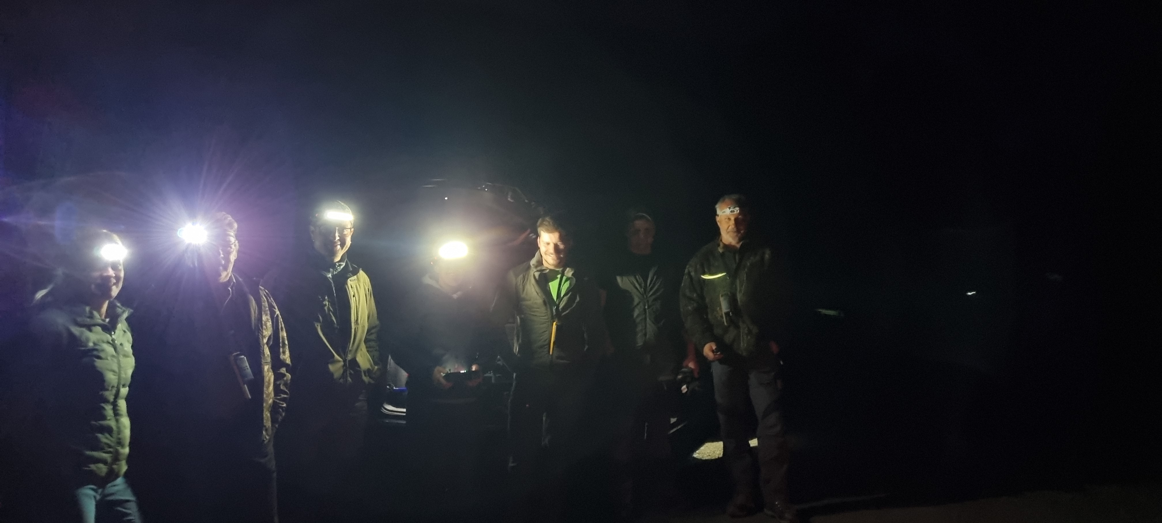 Freiwillige versammeln sich in der Dunkelheit mit Stirnlampen